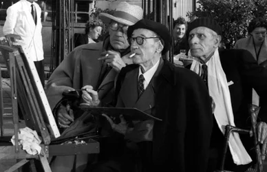 Maurice Utrillo (1883-1955) Målning i Montmartre i Paris, Tertre Square, nära Sacre Coeur, 10 oktober 1955 med Sacha Guitry och Paul Fort när han målade en duk för film om Paris skulle berättas för dig